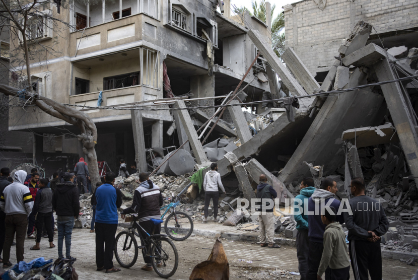 Warga Palestina memeriksa kerusakan bangunan tempat tinggal pasca serangan udara Israel di Rafah, Jalur Gaza selatan, Ahad, 24 Maret 2024.