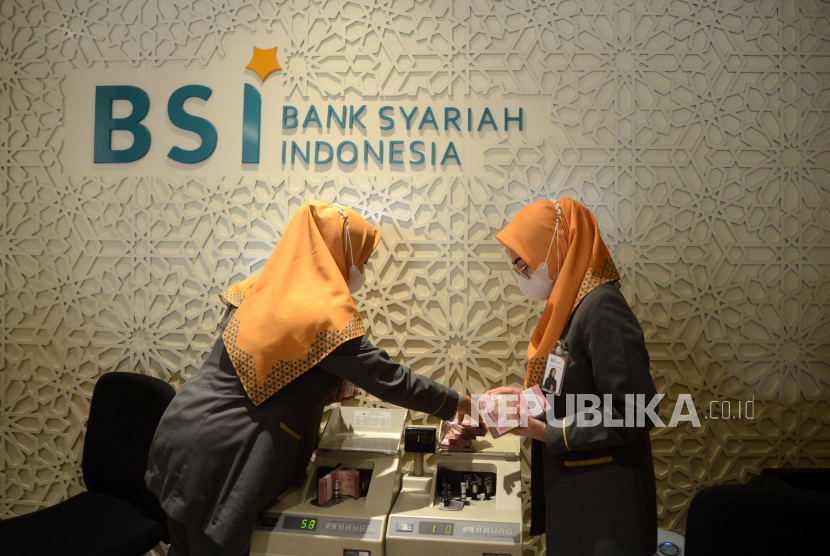 Pegawai  BSI membantu nasabah melakukan transaksi di Kantor Cabang Jakarta Thamrin, Jakarta.