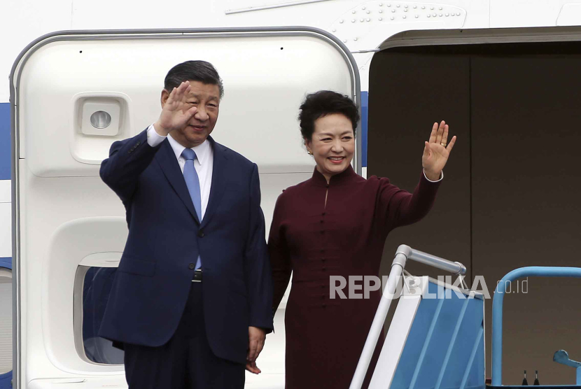 Presiden China Xi Jinping, kiri, dan istrinya Peng Liyuan, kanan, melambai saat mereka tiba di bandara Internasional Noi Bai di Hanoi, Vietnam, Selasa, 12 Desember 2023.