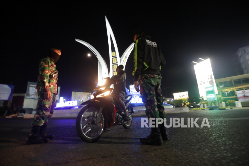 Prajurit Batalyon Raider 112/DJ membantu pengamanan saat pemberlakuan jam malam di Simpang Surabaya, Kota Banda Aceh, Aceh, Rabu (1/4/2020).