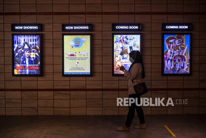 Pengunjung melintas di depan jadwal film yang akan diputar di salah satu bioskop di Palembang, Sumatera Selatan, Rabu (4/11/2020). Pemerintah Kota Palembang kembali mengizinkan bioskop kembali beroperasi dengan menerapkan protokol kesehatan COVID-19. 