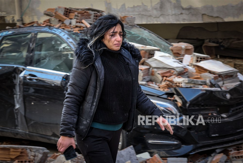  Seorang penyintas berjalan di sekitar kerusakan bangunan yang runtuh di ibu kota Antakya, Provinsi Hatay, provinsi paling selatan Turki setelah gempa kuat, Sabtu (11/2/2023).