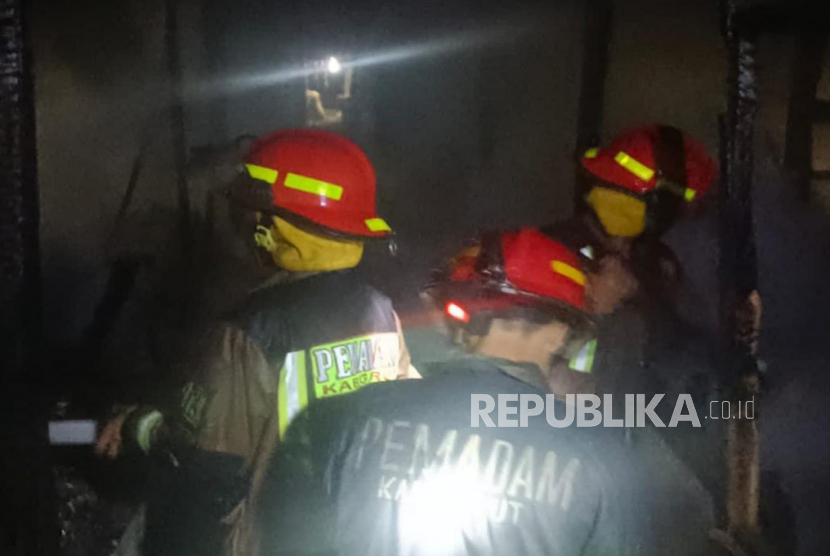 Petugas Dinas Pemadam Kebakaran (Disdamkar) Garut berupaya memadamkan api yang membakar kios di area Blok G Pasar Guntur Ciawitali, Kecamatan Tarogong Kidul, Kabupaten Garut, Jawa Barat, Rabu (24/5/2023).