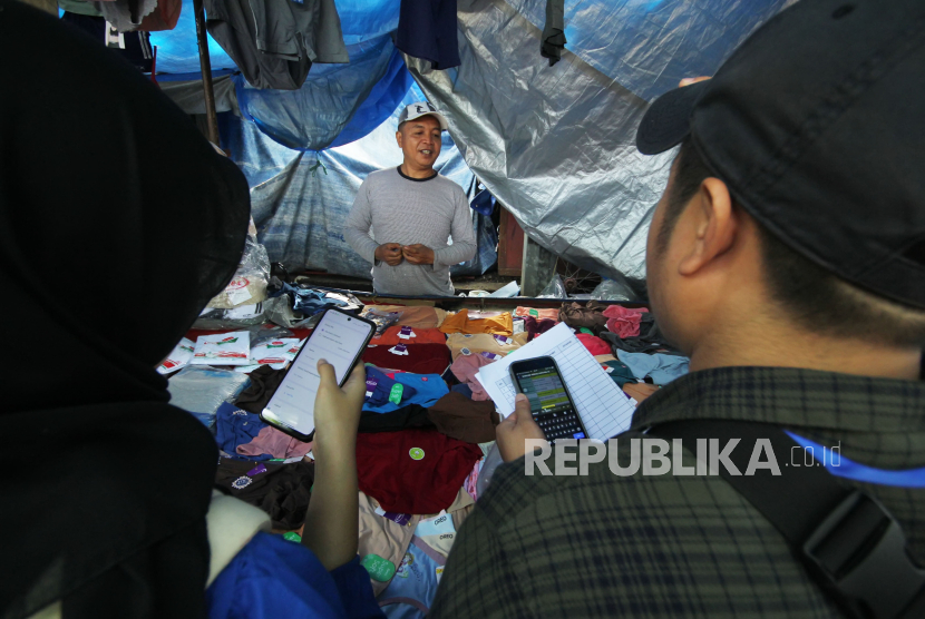 Petugas melakukan pendataan PKL pedagang kaki lima (PKL) di pasar kaget kawasan Monumen Perjuangan Jawa Barat (Monju), Kota Bandung, Ahad (14/1/2024). Sehubungan akan dilakukan penataan dan penertiban PKL di kawasan Monju, Pemkot Bandung dengan melibatkan Bappelitbang, Dinas KUKM, camat, Satpol-PP, dan Dishub melakukan pendataan PKL di kawasan tersebut. Pendataan sebagai salah satu upaya mencegah semakin bertambahnya PKL di pasar tumpah Monju.