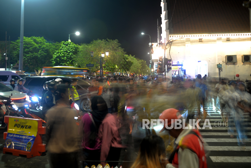 Wisatawan menghabiskan waktu saat libur Nataru 2023 di jalur pedesterian Malioboro, Yogyakarta, Ahad (24/12/2023).