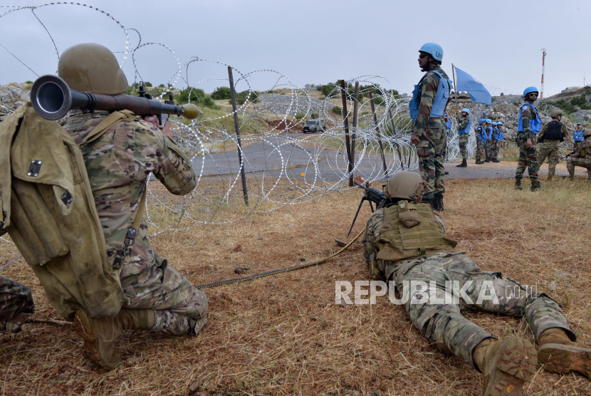  Lebanese soldiers take a position as soldiers of the UN peacekeeping mission, United Nations Interim Force In Lebanon (UNIFIL) keep watch during an anti-Israeli demonstration called by Jemaah Islamiyah (Islamic Group) on the border strip with Israel in the Kfar Chouba area, Southern Lebanon, 09 June 2023. Israeli soldiers fired tear gas to disperse the demonstrators who threw stones at the troops on the Lebanese-Israeli border. Tensions at the border began after Israeli caterpillars tried to dig trenches in an area that Lebanon considers to be Lebanese soil.  