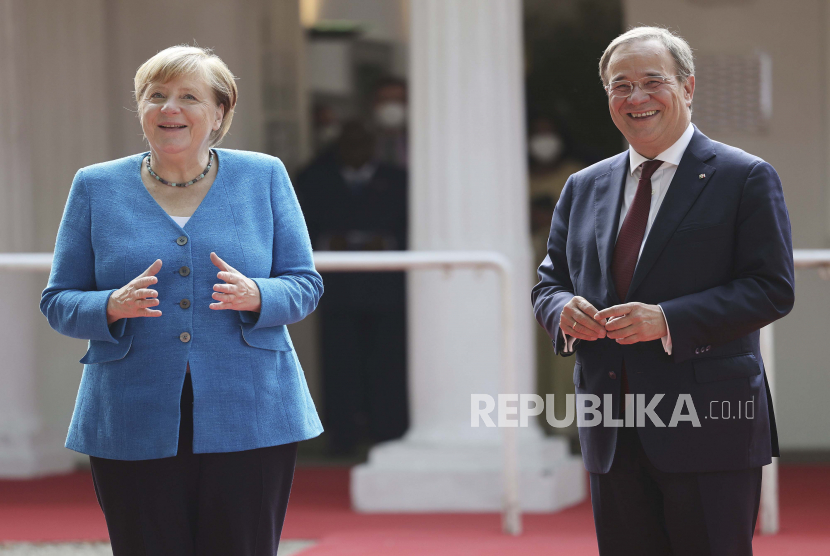 Menteri Presiden Rhine-Westphalia Utara Armin Laschet, kanan, menyambut Kanselir Jerman Angela Merkel, dalam upacara ketika negara bagian North Rhine-Westphalia merayakan ulang tahunnya yang ke-75, di Duesseldorf, Jerman, Senin, 23 Agustus 2021.