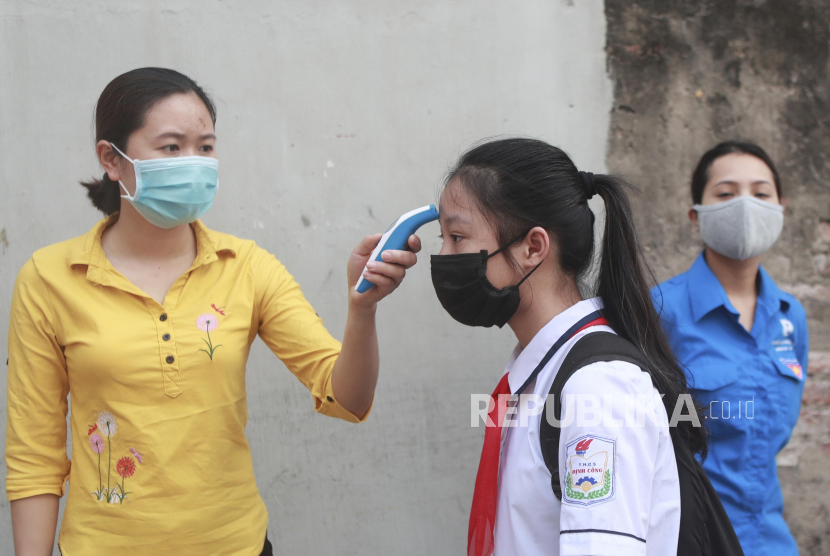 Pemeriksaan temperatur badan di sekolah Vietnam. 