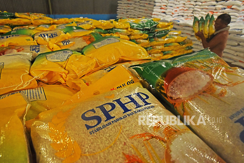 Pekerja mengangkut stok beras kualitas medium kemasan 5 kilogram di gudang Bulog Serang, Banten, Senin (31/7/2023). 