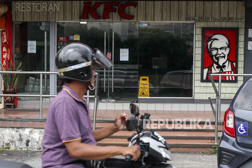 Seorang pengendara sepeda motor melewati restoran Kentucky Fried Chicken (KFC) yang tutup di Sungai Buloh, pinggiran kota Kuala Lumpur, Malaysia, Selasa (30/4/2024). 