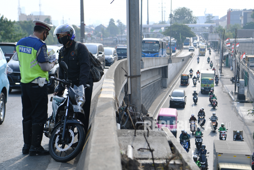 Petugas kepolisian menilang pengendara sepeda motor pada Operasi Patuh Jaya 2020.