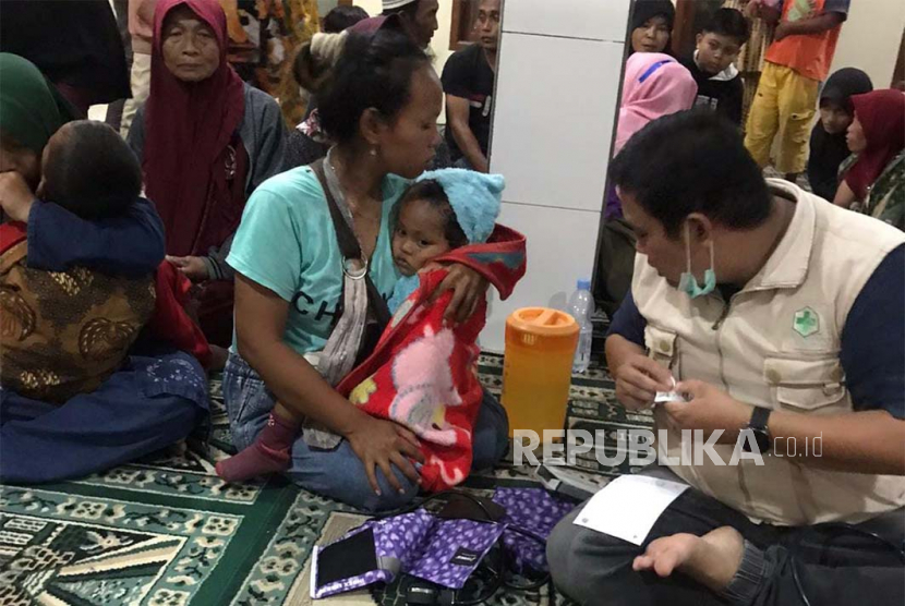 Sejumlah warga yang mengalami gejala keracunan makanan mendapatkan penanganan di masjid wilayah Kecamatan Leuwisari, Kabupaten Tasikmalaya, Jawa Barat, Senin (26/6/2023). 