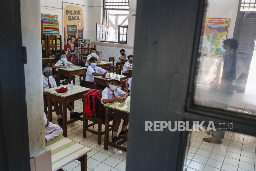  Siswa sekolah dasar menghadiri kelas dalam hari pertama pembukaan kembali sekolah ketika pemerintah melonggarkan pembatasan darurat Covid-19, di Jakarta,  Senin (30/8). Orang tua perlu membiasakan anaknya memakai masker dengan benar sebelum kembali ke sekolah.