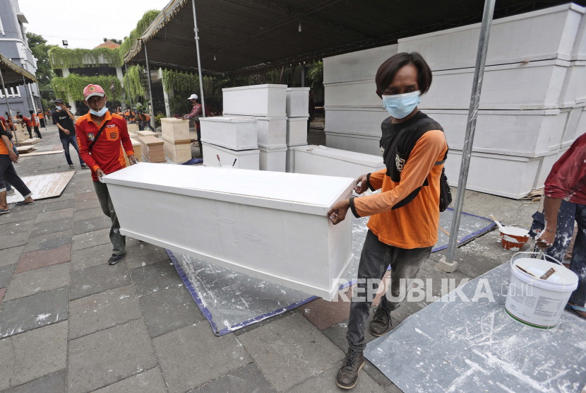 Pekerja membawa peti mati yang dibuat untuk mengantisipasi lonjakan kasus COVID-19, di kompleks gedung pemerintah daerah di Surabaya, Jawa Timur, Indonesia, Sabtu, 3 Juli 2021. 