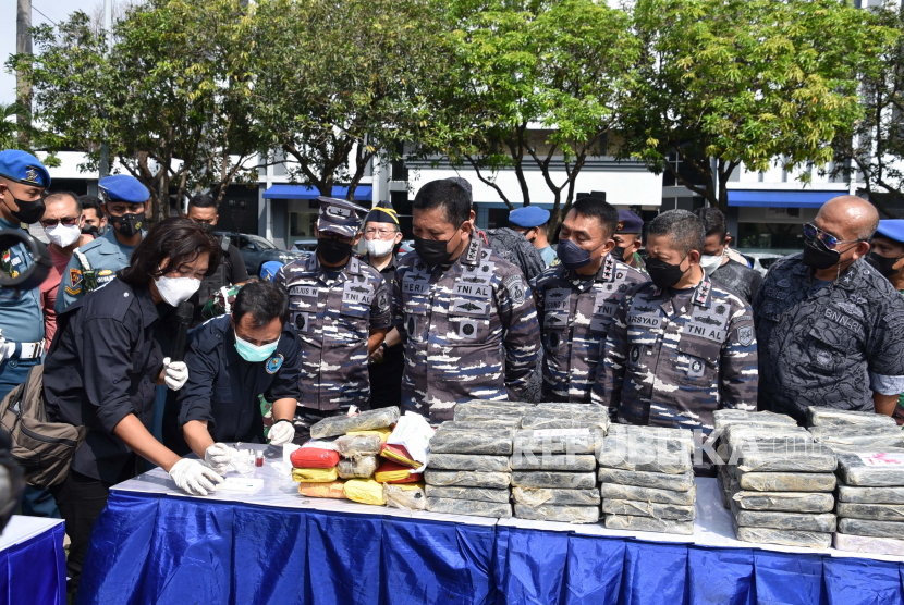 Dalam foto yang dirilis oleh Angkatan Laut Indonesia ini, anggota Badan Narkotika Nasional dan pejabat Angkatan Laut Indonesia memeriksa paket yang berisi 179 kilogram (hampir 400 pon) kokain senilai 1,2 triliun rupiah ($ 82,6 juta) selama konferensi media di markas Armada Barat di Jakarta , Indonesia, Senin, 9 Mei 2022. 