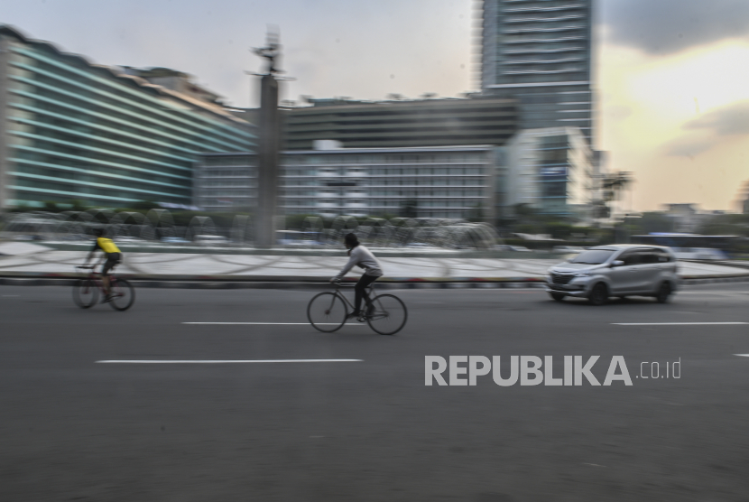 Warga mengayuh sepedanya saat melintas di kawasan Jalan MH Thamrin, Jakarta, Sabtu (27/6).