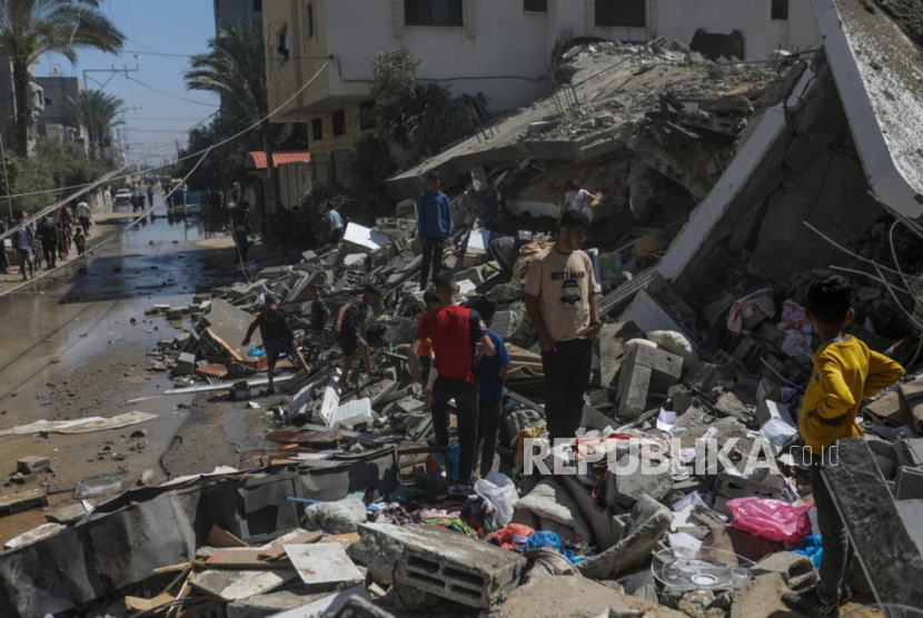 Masyarakat mengamati kerusakan setelah rumah keluarga Abu Al Jidyan hancur akibat serangan udara Israel di Deir Al Balah, Jalur Gaza selatan, (4/4/2024).