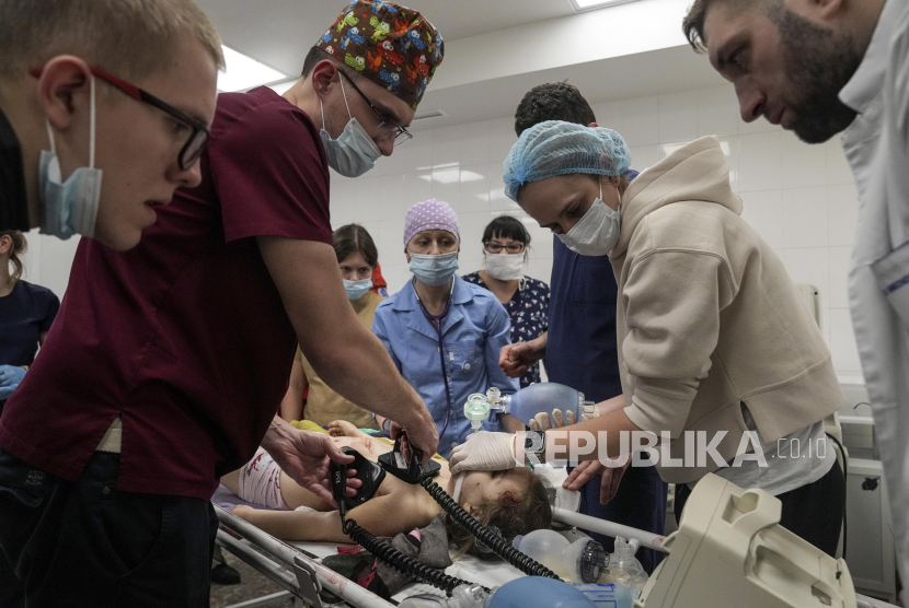 Petugas medis melakukan CPR pada seorang gadis yang terluka dalam penembakan di daerah perumahan, di rumah sakit kota Mariupol, Ukraina timur