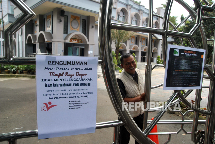 Petugas menutup pintu gerbang masuk di Masjid Raya, Kota Bogor, Jawa Barat, Jumat (3/4/2020). Masjid tersebut untuk sementara tidak menyelenggarakan salat Jumat dan salat wajib berjamaah sebagai upaya pencegahan dan penyebaran wabah virus Corona (COVID-19)