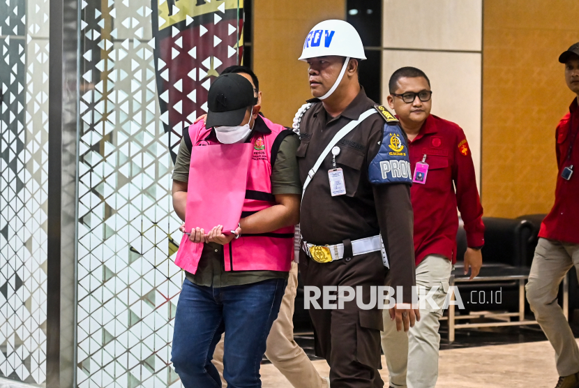 Petugas menggiring Ketua Tim Cyber Army M. Adhiyya Muzakki (kiri) usai menjalani pemeriksaan di Gedung Kejaksaan Agung, Jakarta Selatan, Rabu (7/5/2025) malam WIB.