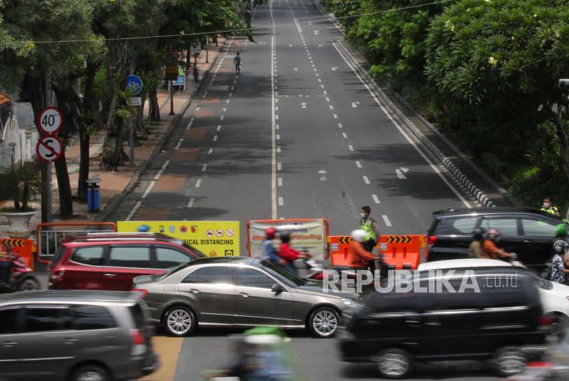 Polisi berjaga saat pemberlakuan kawasan tertib pembatasan sosial akibat pandemi corona di Jalan Darmo, Surabaya, Rabu (1/4).