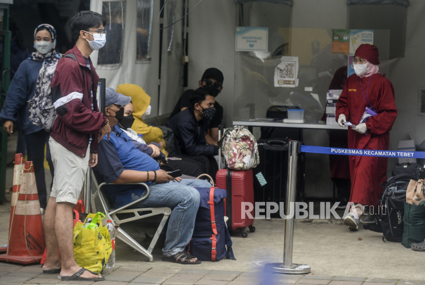 Sejumlah pasien Covid-19 menunggu kedatangan bus sekolah yang akan mengantarkannya menuju RSDC Wisma Atlet di Puskesmas Kecamatan Tebet, Jakarta, Kamis (3/2/2022). Satgas Penanganan Covid-19 mencatat kenaikan kasus positif Covid-19 dalam satu pekan terakhir mencapai 56.000 kasus atau meningkat hingga 40 kali lipat dibandingkan dengan awal Januari lalu. Republika/Putra M. Akbar