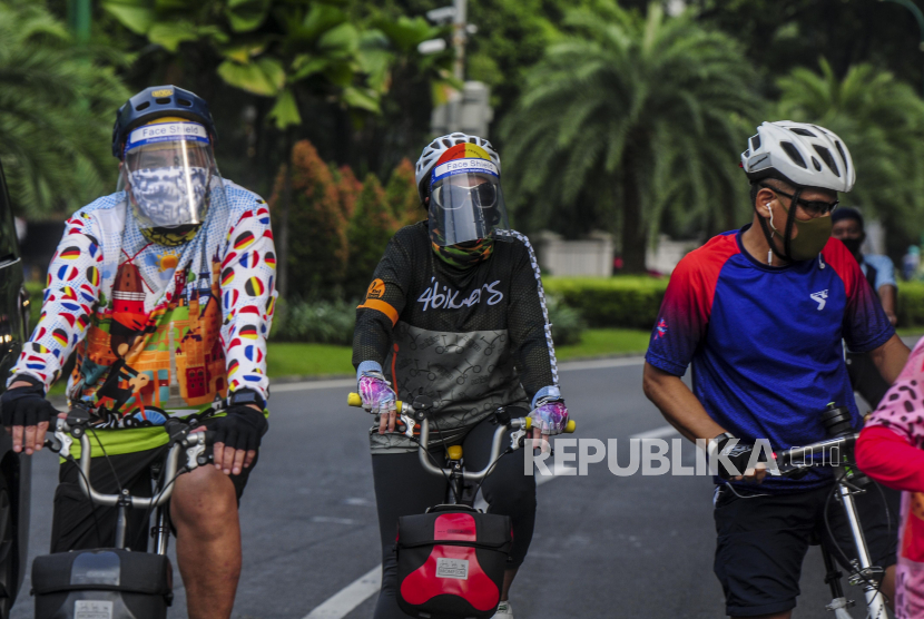 Sejumlah warga saat bersepeda di Jalan Imam Bonjol, Menteng, Jakarta, Ahad (7/6). Pesepeda mengenakan masker dan pelindung wajah saat berolahraga bersama.