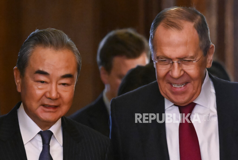 Menteri Luar Negeri Rusia Sergey Lavrov (kanan) dan kepala kebijakan luar negeri Partai Komunis China Wang Yi memasuki aula untuk pembicaraan mereka di Moskow, Rusia,  Rabu (22/2/2023).
