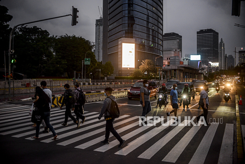 Sejumlah pekerja menyeberangi pelican crossing di kawasan Sudirman, Jakarta, Senin (14/9). Pemerintah Provinsi DKI Jakarta menginstruksikan kapasitas karyawan dalam gedung perkantoran di Jakarta dibatasi maksimal hanya 25 persen. Republika/Putra M. Akbar