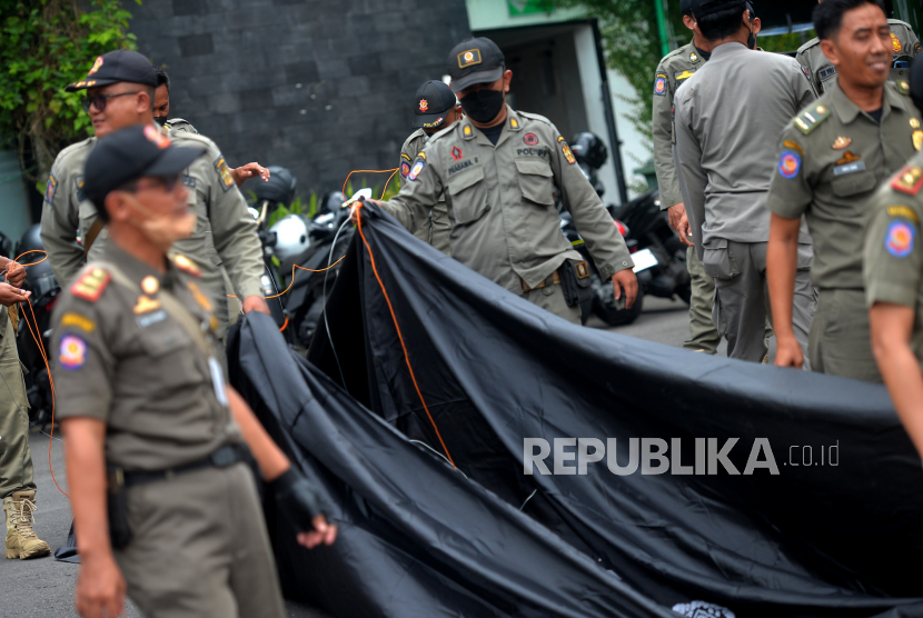 Satpol PP Kota Yogyakarta bersiap  menertibkan reklame di Jalan Pasar Kembang, Yogyakarta.