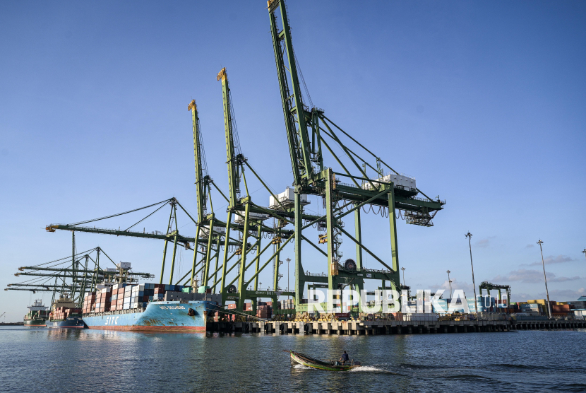 Kapal nelayan melintas dengan latar belakang aktivitas bongkar muat peti kemas di New Priok Container Terminal One, Jakarta, Selasa (1/7/2025). 