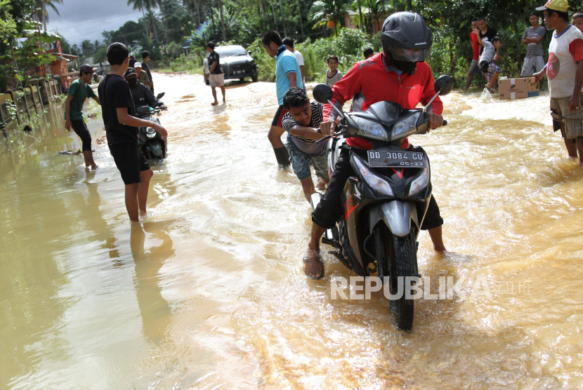 Pengendara menerobos banjir di jalan Trans Sulawesi yang terendam banjir di Kecamatan Morosi, Konawe, Sulawesi Tenggara, Jumat (17/7/2020). Jalan Trans Sulawesi penghubung antara Sulawesi Tenggara dan Sulawesi Tengah tersebut rusak akibat banjir luapan Sungai Konaweha. 