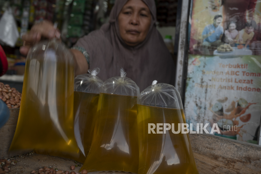 Pedagang menata minyak goreng curah. Holding BUMN Pangan, ID Food, mendistribusikan minyak goreng kepada pedagang di Pasar Kramat Jati, Jakarta Timur, Sabtu (5/2/2022).