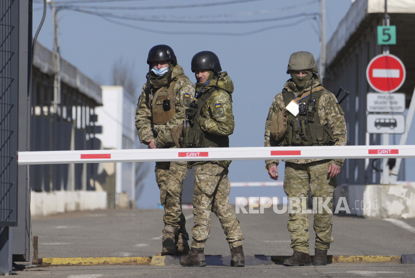 Penjaga perbatasan Ukraina berdiri di sebuah pos pemeriksaan dari wilayah yang dikendalikan oleh separatis yang didukung Rusia ke wilayah yang dikendalikan oleh pasukan Ukraina di Novotroitske, Ukraina timur, Senin, 21 Februari 2022. 