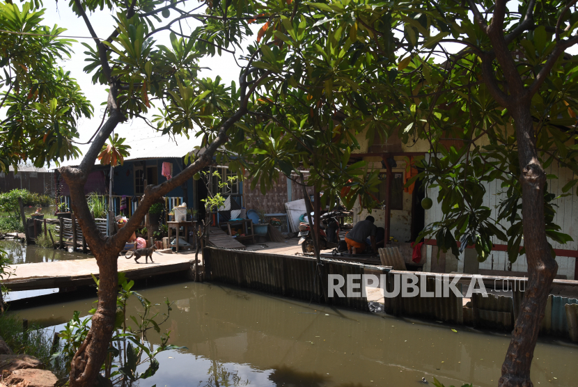 Warga beraktivitas di depan rumahnya di Jalan Kamal Muara, Jakarta Utara. Menurut warga setempat, permukiman tersebut rentan banjir akibat luapan Kali Semonggol dan rob dari muara di Kamal Muara. 