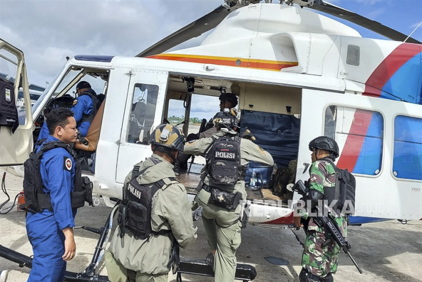 Sebuah foto handout yang disediakan oleh Mabes Polri menunjukkan personel polisi dan TNI naik helikopter selama operasi pencarian dan penyelamatan untuk pilot Susi Air dan penumpang di bandara di Timika, Papua, (ilustrasi).