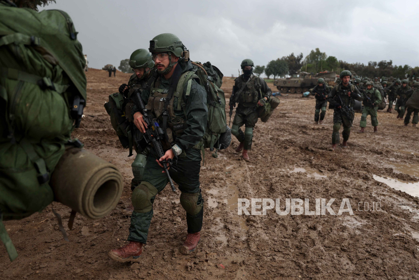 Tentara Israel berjalan di posisi dekat perbatasan Gaza, di Israel selatan, 13 Desember 2023. 
