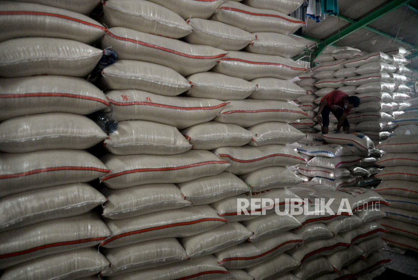 Sejumlah pekerja menata tumpukan karung beras di Pasar Induk Cipinang , Jakarta Timur, Selasa (27/10). 