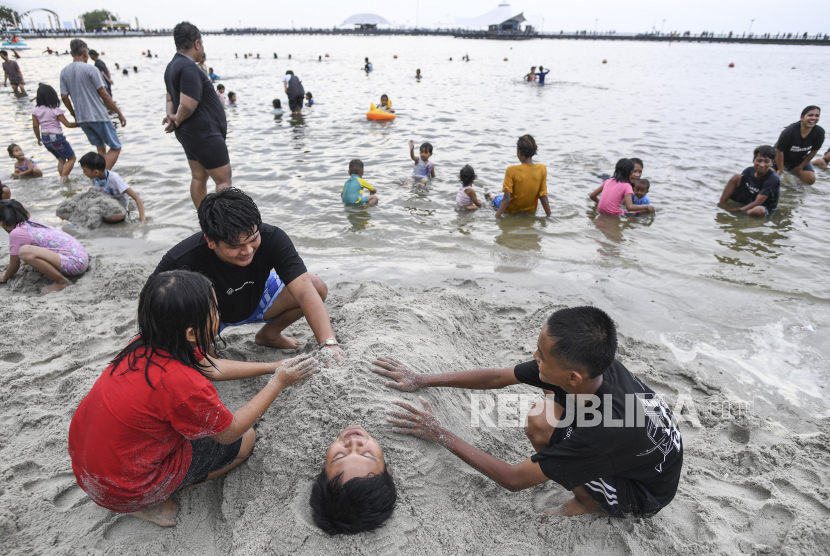 Pengunjung bermain pasir di kawasan pantai Ancol, Jakarta. (ilustrasi). Taman Impian Jaya Ancol mencatat jumlah pengunjung kawasan wisata tersebut pada H-1 Natal hingga pukul 12.00 WIB 46.900 orang.