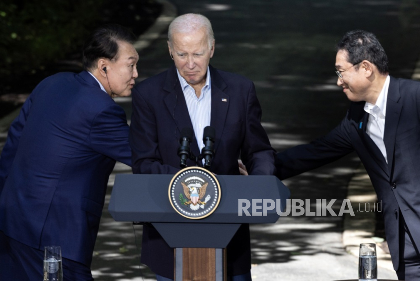 Presiden Korsel Yoon Suk Yeol (kiri) berjabat tangan dengan PM Jepang Fumio Kishida (kanan) di depan Presiden AS Joe Biden selama konferensi pers di Camp David, Maryland, AS, 18 Agustus 2023.