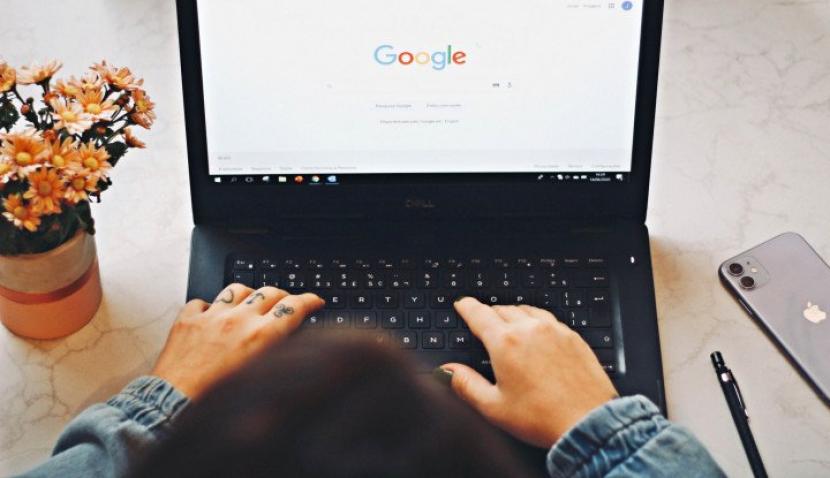 seorang wanita  membuka google di laptop. (Unsplash/Nathana Rebouças)