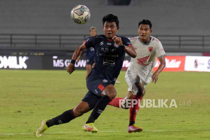 Pesepak bola Arema FC Dedik Setiawan (kiri) berebut bola dengan pesepak bola PSM Makassar Manda Cingi (kanan) pada pertandingan Liga 1 di Stadion Kapten I Wayan Dipta, Gianyar, Bali, Rabu (30/3/2022). Arema FC menang atas PSM Makassar dengan skor 1-0. 