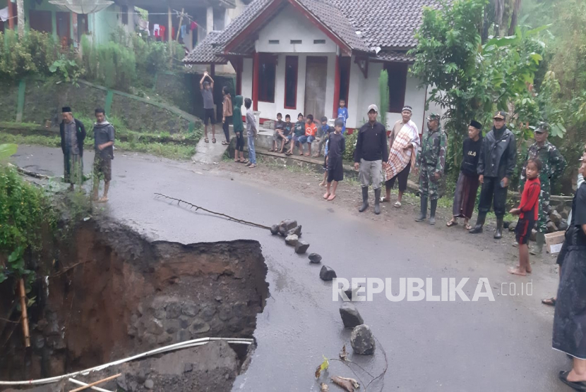 Petugas meninjau jalan yang ambles di Desa Karangagung, Kecamatan Singajaya, Kabupaten Garut, Ahad (29/1/2023). 
