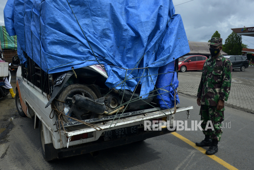 Anggota TNI memberhentikan kendaraan yang membawa kendaraan milik pemudik di perbatasan Kabupaten Takalar-Jeneponto, Sulawesi Selatan, Jumat (7/5/2021). Pemeriksaan kendaraan antar kabupaten tersebut sebagai upaya untuk menyekat warga yang nekat mudik jelang Hari Raya Idul Fitri 1442 H di wilayah Sulawesi Selatan.
