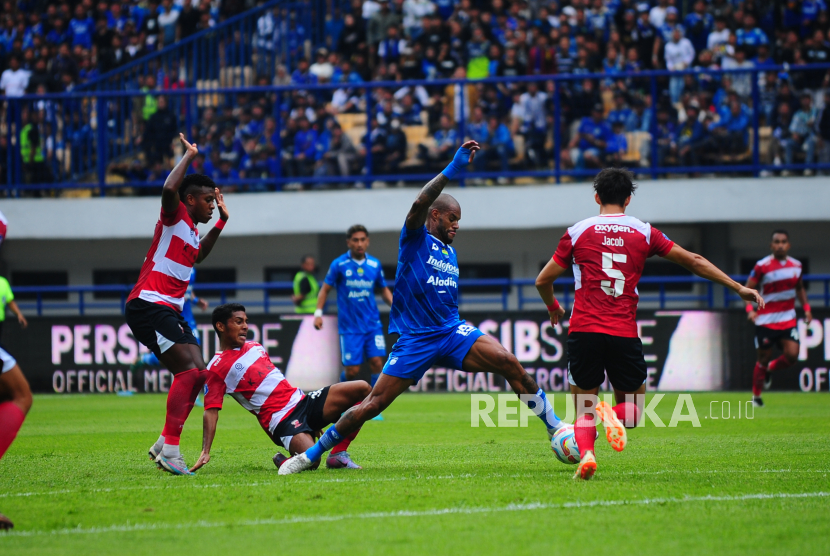 Striker Persib Bandung David da Silva (jersei biru) berebut bola dengan pemain Madura United pada laga Liga 1 Indonesia 2023/2024 di Stadion GBLA, Kota Bandung, Jawa Barat, Ahad (2/7/2023). 