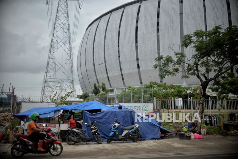 Warga korban gusuran Kampung Bayam beraktivitas di tenda darurat yang didirikan di depan pintu masuk Jakarta International Stadium (JIS). Anggota DPRD DKI minta Erick Thohir ikut bantu perbaiki JIS.