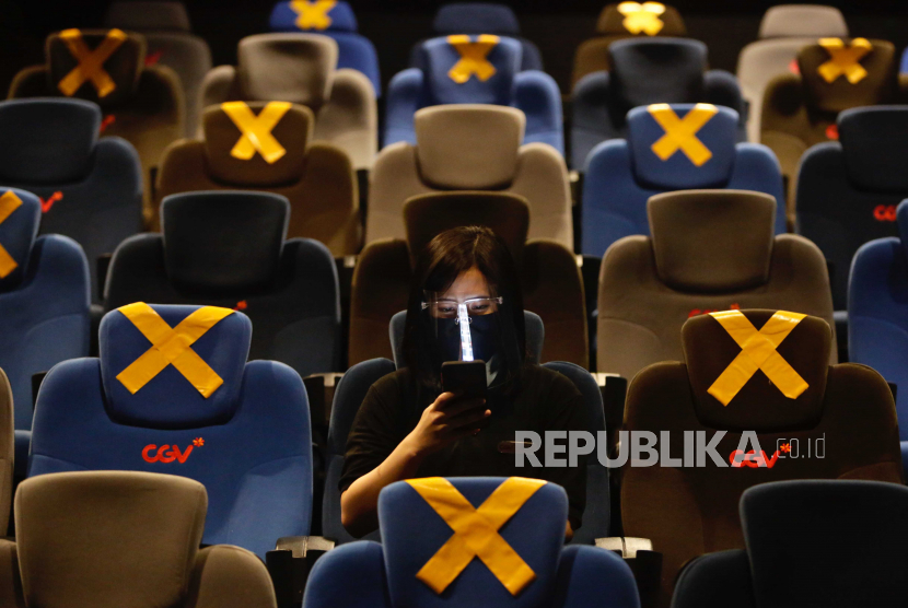 Seorang penonton duduk di dalam bioskop menunggu film dimulai di Jakarta, Indonesia.