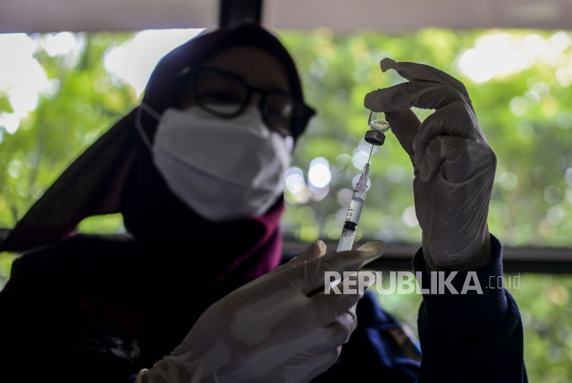 Tenaga kesehatan memasukan dosis vaksin Covid-19 di SDN Cilandak Barat 04, Jakarta, Selasa (14/12). 