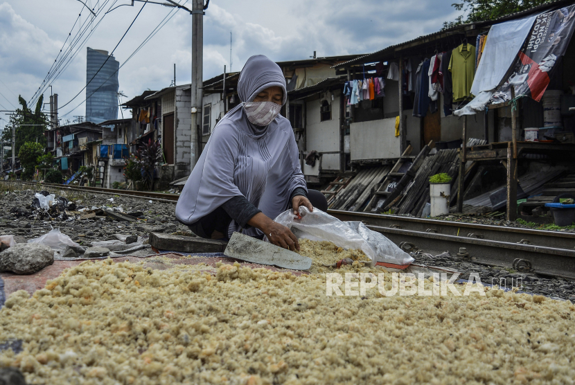 Seorang warga mengambil nasi kering untuk pakan unggas di jalur kereta api Palmerah-Tanah Abang, Jakarta, Selasa (27/10/2022). Pemerintah telah mengucurkan anggaran Rp450 triliun guna merealisasikan penghapusan kemiskinan ekstrem yang mencapai 5,59 juta orang di Indonesia melalui sinergi program antar kementerian/lembaga maupun pemerintah daerah. 