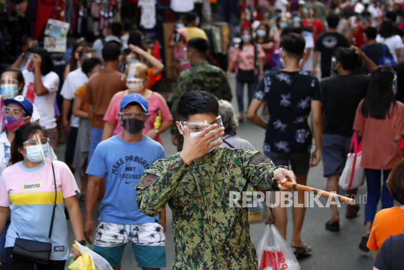  Seorang polisi memberikan isyarat tongkat kepada pembeli di sepanjang jalan di Manila, Filipina, ilustrasi